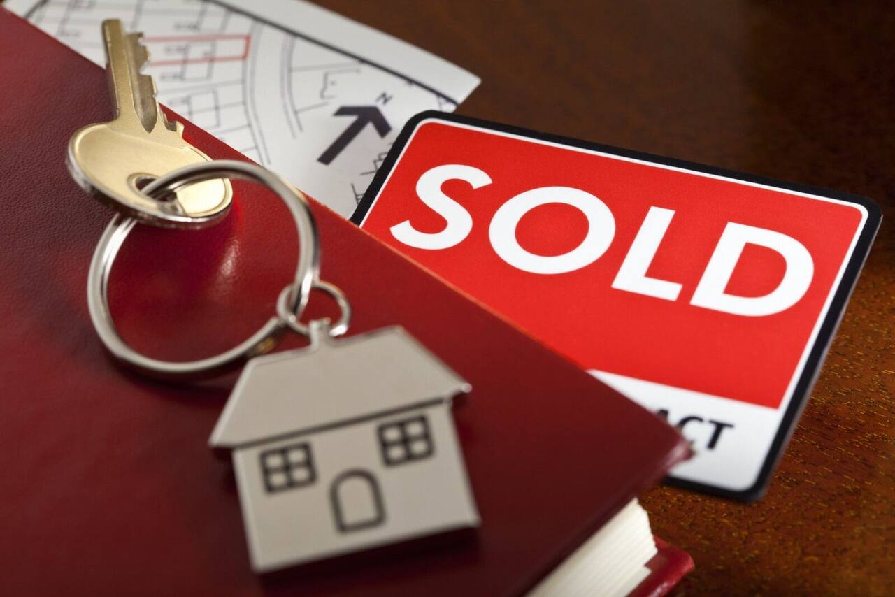 House keys on a sold sign